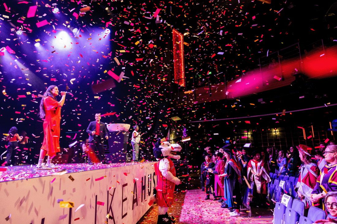 Performers on stage under confetti during the Northeastern London Convocation.