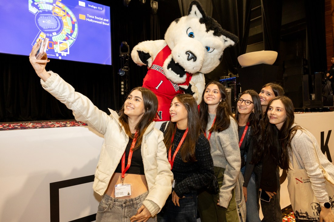 Northeastern students taking a selfie with Paws, Northeastern's mascot.