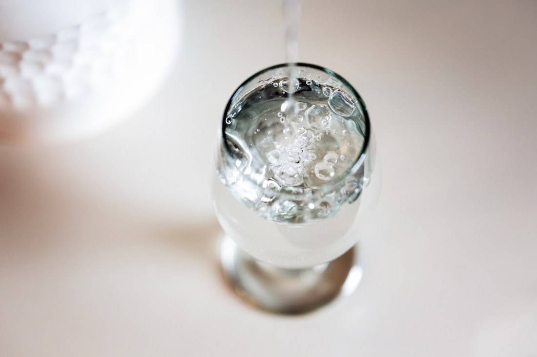 A glass of water depicted from above and against a white backdrop.