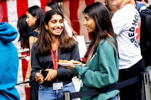 Two female students shown chatting at Husky Fest on the London campus.