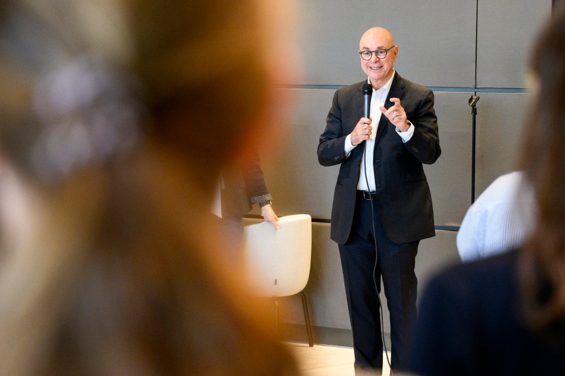 Joseph E. Aoun shown gesturing while speaking into a microphone at the event.