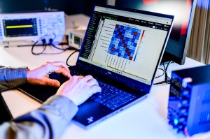 A person typing on a laptop displaying technical, network information.